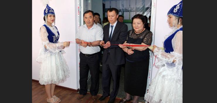 Keneshbek Usenov, Rector of Jalal-Abad State University (left), Ruslan Moldokasymov, EWMI CGP Deputy Chief of Party (second from left), and Irys Beibutova, Coordinator of NPM Resource Center in Bishkek and representative of the Association of NPM Educators (to the right) cut a ribbon to inaugurate the new NPM Resource Center at Jalal-Abad State University.