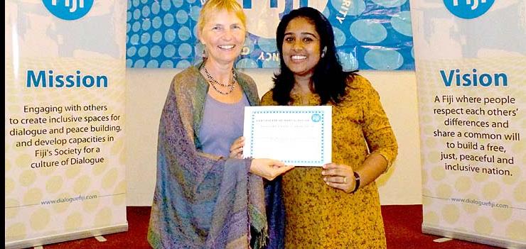 Alzima Bano, one of the mediators at the training on dialogue facilitation, receives her certificate from Lead Facilitator Sylvia McMechan.